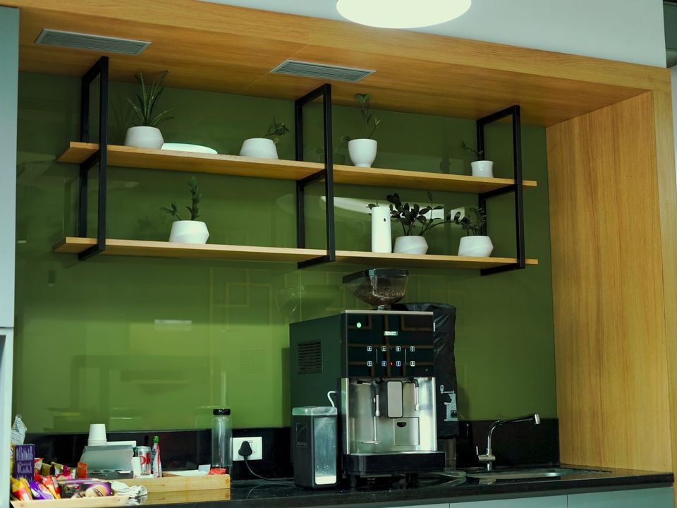 An office kitchen with a coffee machine and tidy shelves